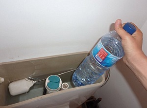 insert-filled-water-bottle-in-toilet-cistern